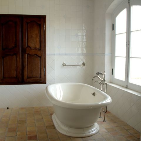 Freestanding tub beside an arched window